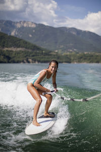 Full length of smiling young woman in water