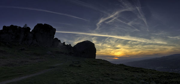 Rock formations on landscape against sky during sunset