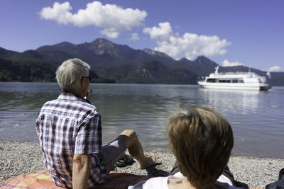 Rear view of senior couple looking at ship in kochelsee