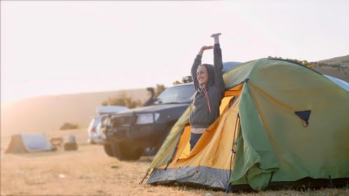 People in tent on land against sky