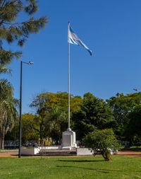 Low angle view of flags against clear sky