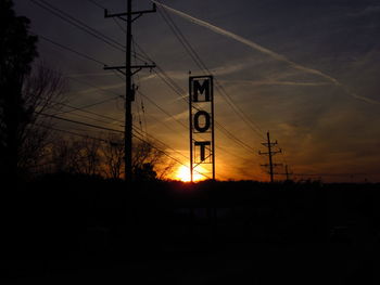 Silhouette electricity pylon against sky during sunset