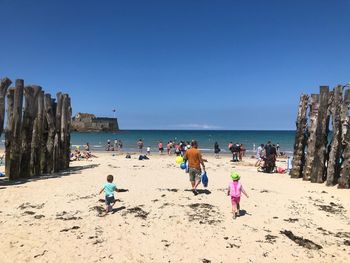 People on beach against clear sky