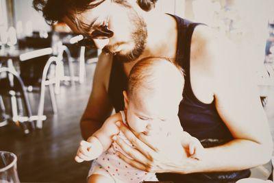 Father holding baby girl in restaurant