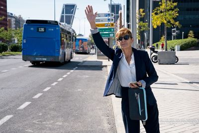 Woman holding umbrella while standing on road