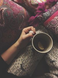 High angle view of woman holding coffee cup on table