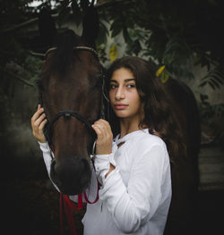 Portrait of young woman riding horse in park