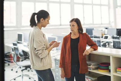Mature businesswoman talking with female colleague in office