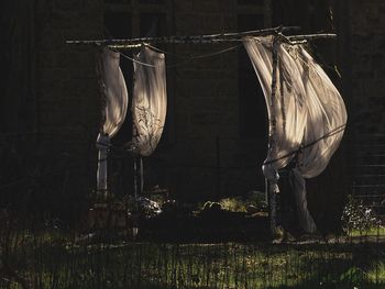 Clothes drying on wooden post at night
