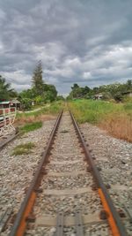 Railway tracks on landscape against sky