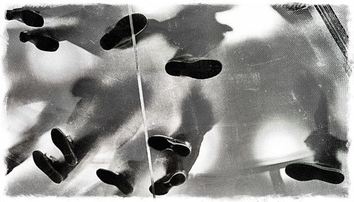 Directly below shot of human legs on glass floor