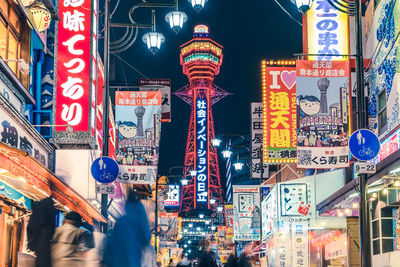 Illuminated street shinsekai hitachi building at osaka city at night