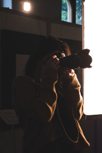 Close-up of young woman holding camera