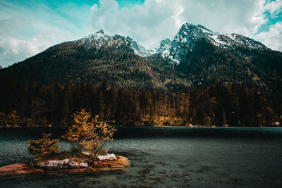 Scenic view of lake by mountains against sky