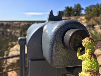 Close-up of coin-operated binoculars against sky on sunny day