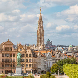 Buildings in city against cloudy sky