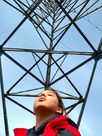 Low angle view of boy against clear blue sky