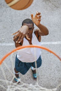 High angle view of basketball player making basket while standing at court