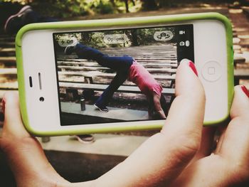 Cropped image of woman holding smart phone