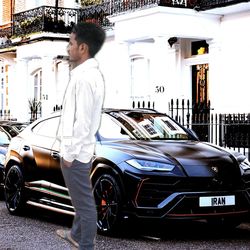 Side view of man standing by car in city