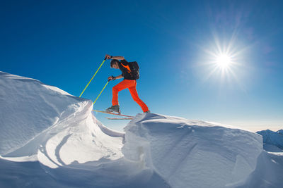 Person skiing on snowcapped mountain against sky