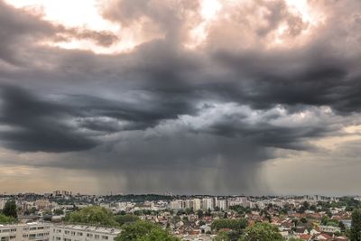 Aerial view of city against dramatic sky