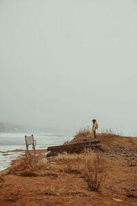Man standing on beach against clear sky