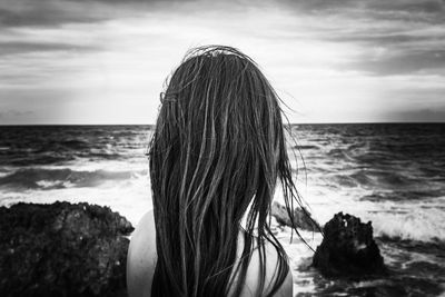 Rear view of woman looking at sea shore against sky