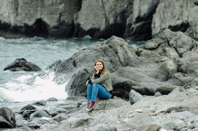 Portrait of woman sitting on rock