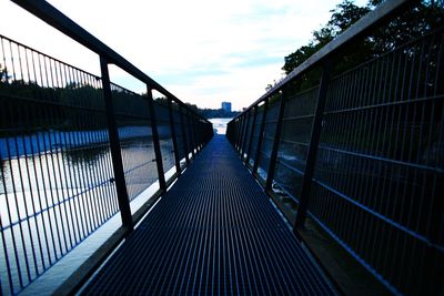 Empty footbridge against sky