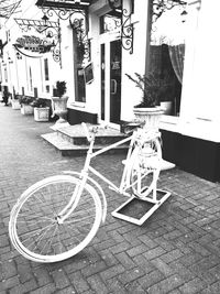 Bicycle on sidewalk by building in city