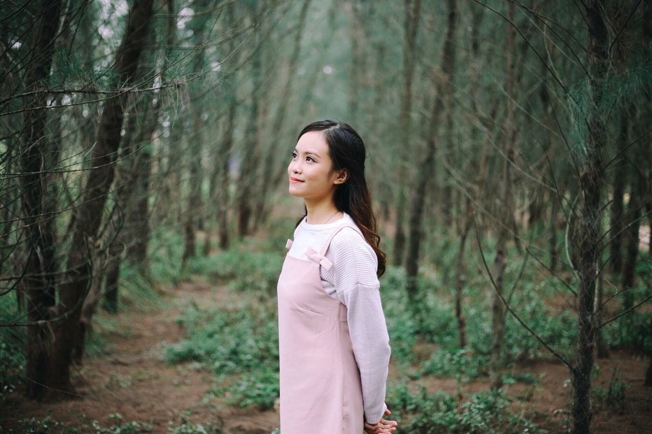 forest, one person, tree, lifestyles, smiling, outdoors, young adult, leisure activity, nature, black hair, day, portrait, young women, tree trunk, women, standing, beautiful woman, cheerful, real people, happiness, beauty, beauty in nature, adult, adults only, people