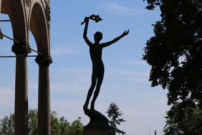 Low angle view of silhouette statue against sky