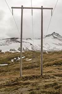 Wooden electricity poles with power lines in a mountain landscape 