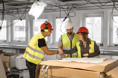 Workers reviewing blueprint at construction site