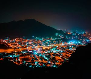 Illuminated cityscape against sky at night