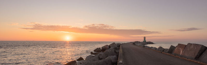 Pier over sea against sky during sunset