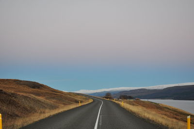 Road passing through landscape against sky