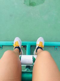 Low section of woman sitting on metal