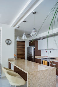 Modern wooden kitchen, with black or gray granite bar, with tile backsplash, light floor.