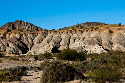 Rock formations on landscape against clear sky