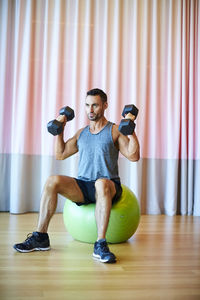 A man doing shoulder presses in the gym.