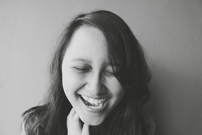 Portrait of a smiling young woman against wall