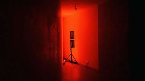 Lighting equipment against red wall in darkroom