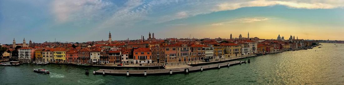 Boats moored in sea against sky during sunset