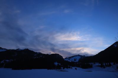 Scenic view of snowcapped mountains against sky at dusk