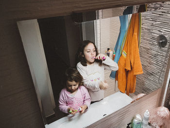 Full length of mother and girl sitting on floor