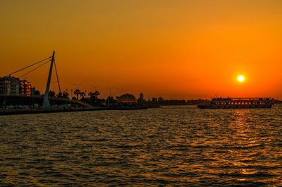 Boats in sea at sunset