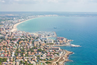 High angle view of townscape by sea against sky