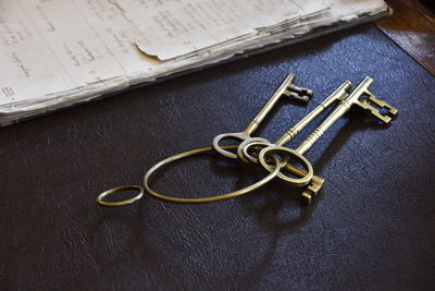 Close-up of old-fashioned keys by papers on table